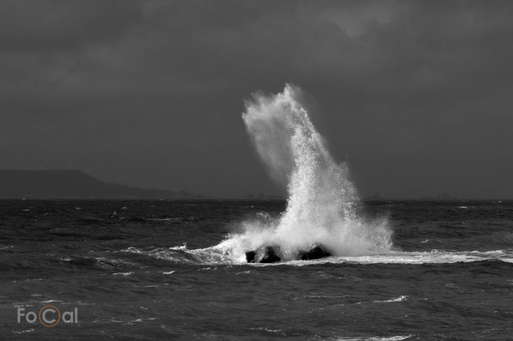 Photo of waves crashing into a rock